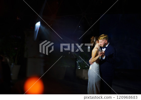 The bride and groom dance the first dance at the wedding banquet. 120968683