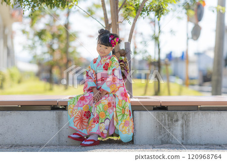 穿著七五三和服的女孩在公園裡微笑 120968764