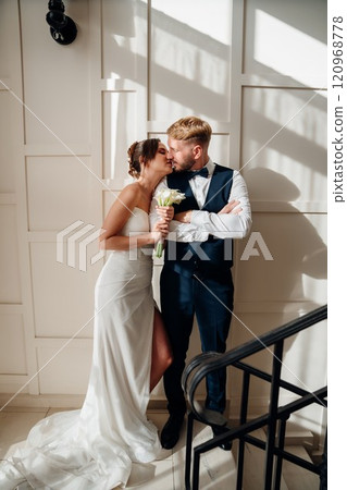 Portrait of a beautiful groom and a bride against the white wall Portrait of a beautiful groom and a bride against the white wall 120968778