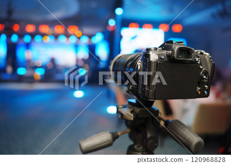 A professional videographer is filming a concert on stage. blurred stage. A professional videographer is filming a concert on stage. blurred stage. 120968828
