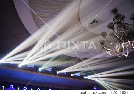 spotlight beams on the ceiling of the banquet hall.  120968831