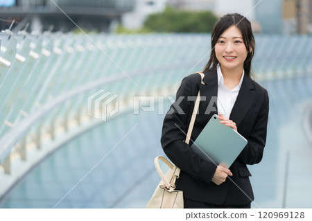 穿著西裝、在辦公區拿著平板電腦的女商人 穿著西裝、在辦公區拿著平板電腦的女商人 120969128