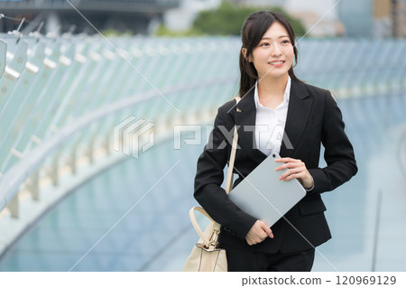 穿著西裝、在辦公區拿著平板電腦的女商人 穿著西裝、在辦公區拿著平板電腦的女商人 120969129