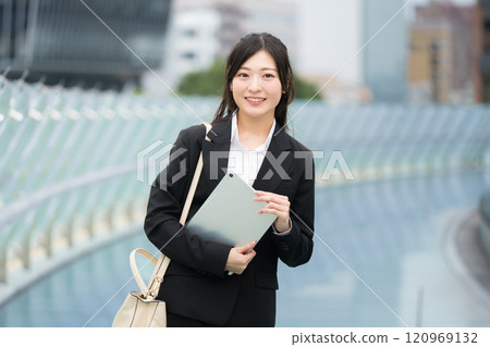 穿著西裝、在辦公區拿著平板電腦的女商人 120969132