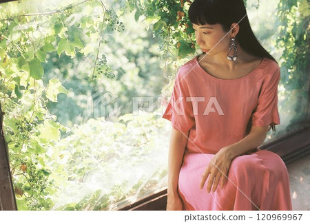 A woman sitting on the window side 120969967