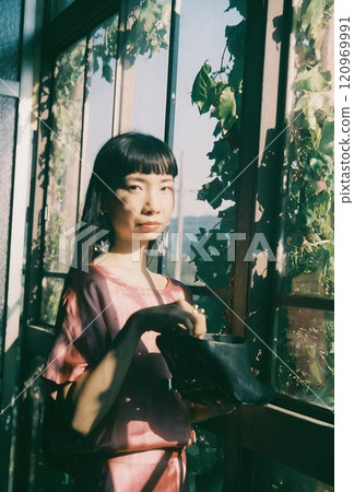 A charming woman by the green window 120969991