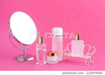Makeup products and a mirror on a pink background 120970400