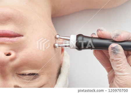 Caucasian female receiving anti aging facial treatment with microcurrent therapy Caucasian female receiving anti aging facial treatment with microcurrent therapy 120970700