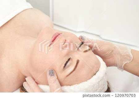Young caucasian woman receiving facial massage in spa treatment for relaxation 120970703