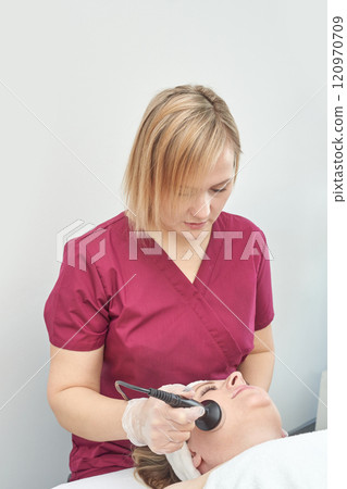 Female caucasian beautician performing facial treatment on a young woman Female caucasian beautician performing facial treatment on a young woman 120970709