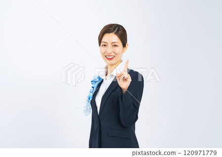 A middle-aged woman in a suit pointing and smiling 120971779