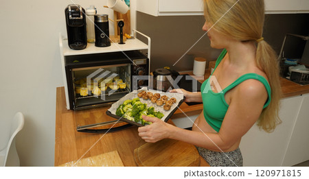 A young woman joyfully prepares a variety of healthy meals  120971815