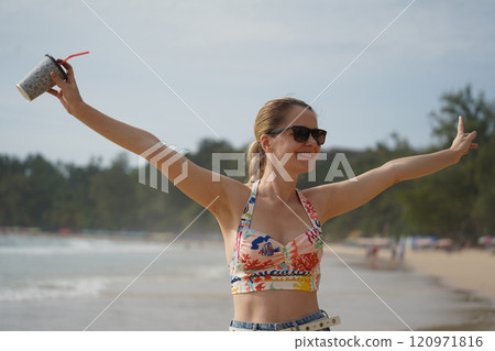 A young woman enjoying a beautiful day at the beach  120971816