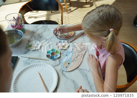 A young mother and her daughter enjoy a creative art session at home  120971835