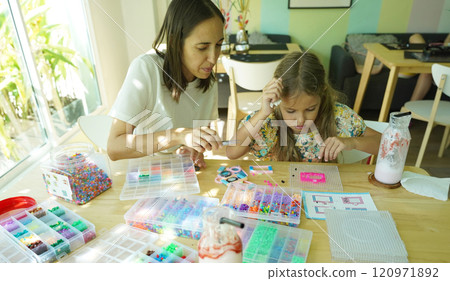 Teacher in workshop teched two girls how to assemble a thermo mosaic Teacher in workshop teched two girls how to assemble a thermo mosaic 120971892