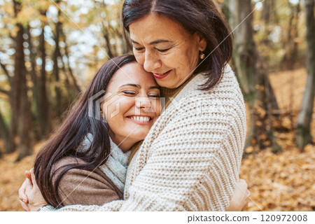 Mature daughter with older mom in the middle of fores, hugging. Mother's day concept. Mature daughter with older mom in the middle of fores, hugging. Mother's day concept. 120972008