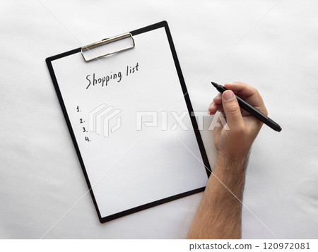 Handwriting a minimalist shopping list on clipboard 120972081