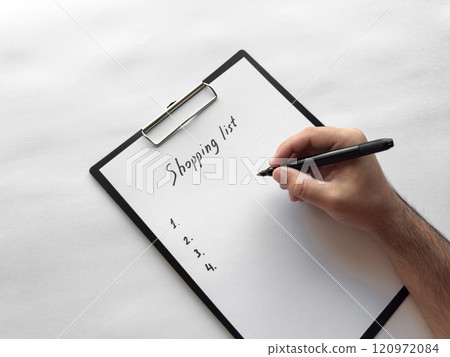 Hand writing shopping list on clipboard with pen on white background 120972084