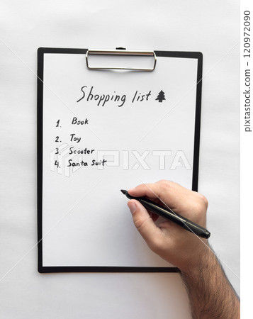 Hand writing a shopping list on clipboard with pen 120972090