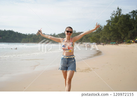 A young woman enjoying a beautiful day at the beach A young woman enjoying a beautiful day at the beach 120972155