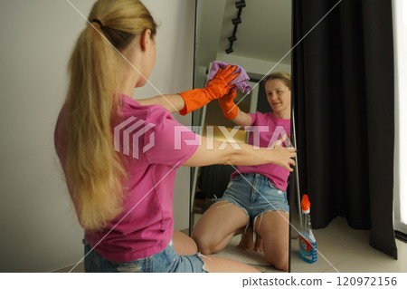 A woman is cleaning her living room at home 120972156