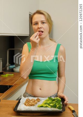 A young woman joyfully prepares a variety of healthy meals  120972265