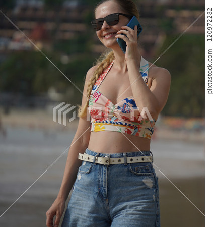 A young woman enjoying a beautiful day at the beach  120972282