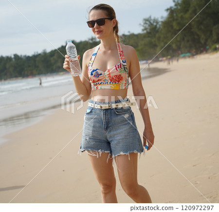A young woman enjoying a beautiful day at the beach  120972297