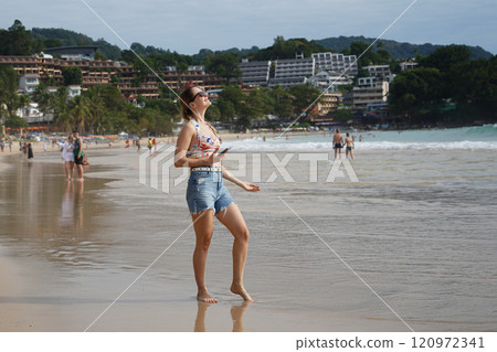 A young woman enjoying a beautiful day at the beach A young woman enjoying a beautiful day at the beach 120972341