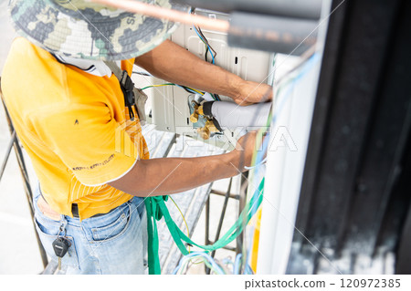 Technician install air conditioner outdoor unit Technician install air conditioner outdoor unit 120972385