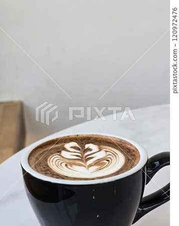 Artistic Latte in Black Mug on Wooden Table 120972476