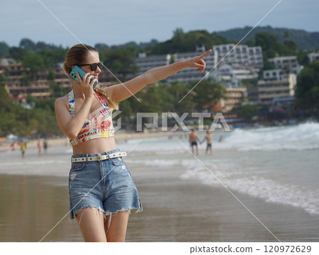 A young woman enjoying a beautiful day at the beach A young woman enjoying a beautiful day at the beach 120972629