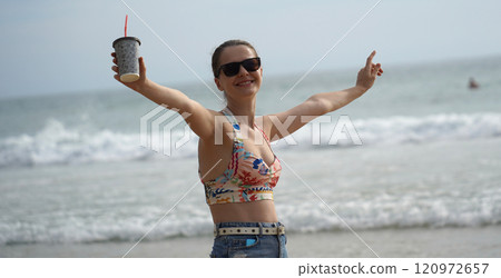 A young woman enjoying a beautiful day at the beach  120972657
