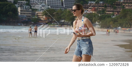 A young woman enjoying a beautiful day at the beach  120972826