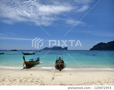 A serene and beautiful tropical beach paradise featuring traditional boats A serene and beautiful tropical beach paradise featuring traditional boats 120972954