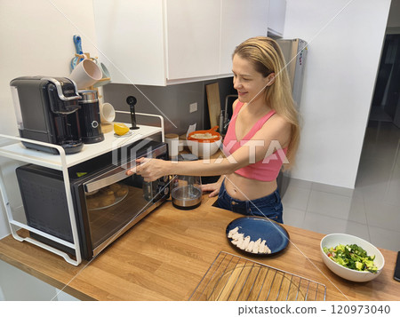 A young woman prepares a fresh meal A young woman prepares a fresh meal 120973040