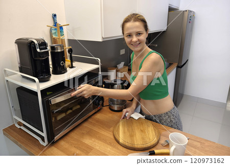 A young woman joyfully prepares a variety of healthy meals  120973162