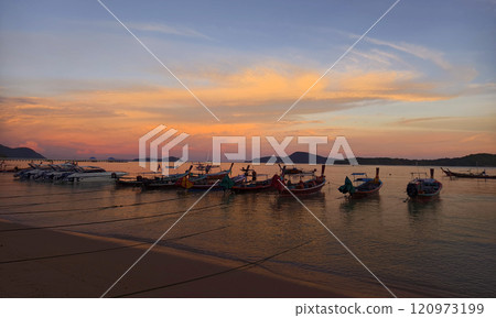 A beautifully serene view of a stunning sunset with fishing boats A beautifully serene view of a stunning sunset with fishing boats 120973199