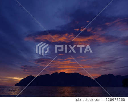 A stunning sunset is casting vibrant hues of color over a tranquil ocean A stunning sunset is casting vibrant hues of color over a tranquil ocean 120973260