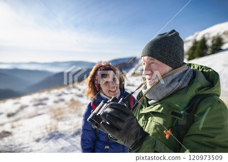 Romantic winter hike for an elderly couple in snowy mountains. Active seniors enjoying nature. Romantic winter hike for an elderly couple in snowy mountains. Active seniors enjoying nature. 120973509
