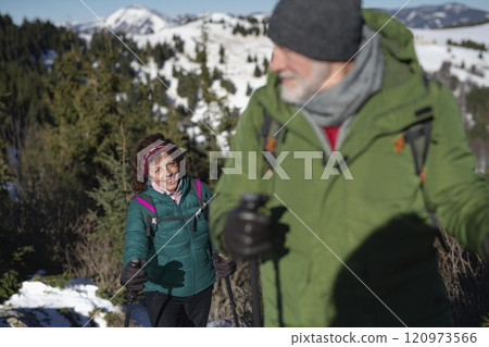 Elderly woman during winter hike in snowy mountains. Active female seniors enjoying nature. 120973566