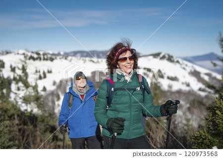 Active seniors enjoying winter nature. Romantic winter hike for an elderly couple in snowy mountains. 120973568