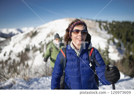 Portrait of elderly woman during winter hike in snowy mountains. Active female senior enjoying nature. 120973609
