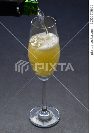 將冷藏好的香檳(起泡酒)倒入長笛杯中 將冷藏好的香檳(起泡酒)倒入長笛杯中 120973692