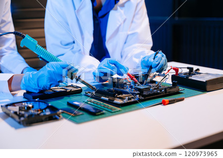 The technician is putting the CPU on the socket of the computer motherboard. electronic engineering 120973965