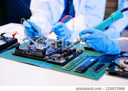 The technician is putting the CPU on the socket of the computer motherboard. electronic engineering 120973966