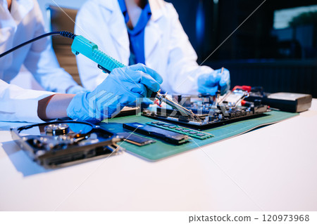 The technician is putting the CPU on the socket of the computer motherboard. electronic engineering The technician is putting the CPU on the socket of the computer motherboard. electronic engineering 120973968