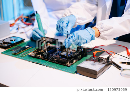 The technician is putting the CPU on the socket of the computer motherboard. electronic engineering 120973969