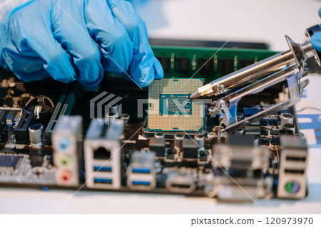 The technician is putting the CPU on the socket of the computer motherboard. electronic engineering 120973970