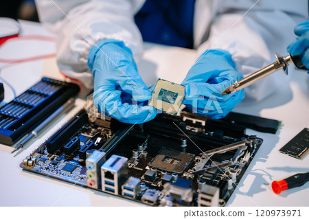 The technician is putting the CPU on the socket of the computer motherboard. electronic engineering 120973971